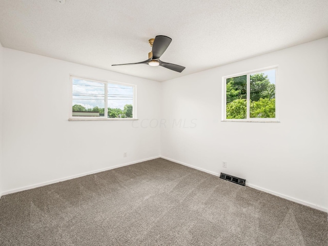 carpeted empty room with ceiling fan and a textured ceiling