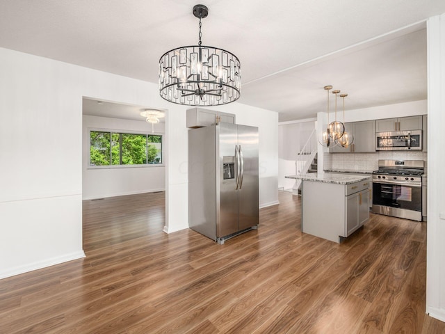 kitchen featuring gray cabinets, a center island, dark hardwood / wood-style flooring, and appliances with stainless steel finishes