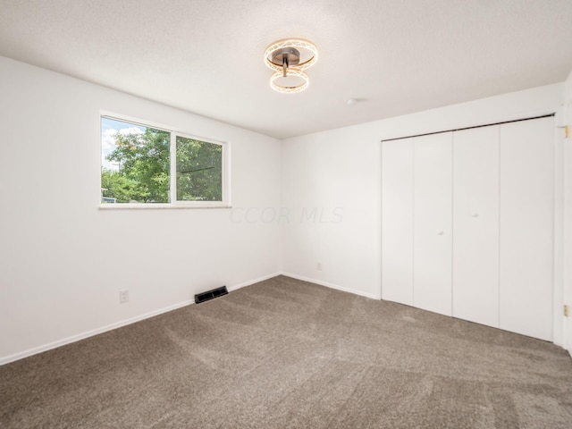 unfurnished bedroom featuring carpet and a closet