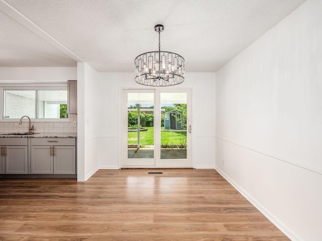 unfurnished dining area with plenty of natural light, light wood-type flooring, and sink