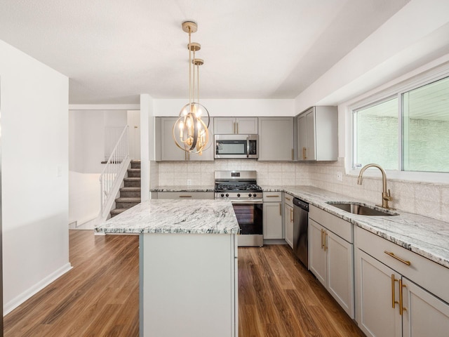 kitchen featuring pendant lighting, a center island, sink, dark hardwood / wood-style flooring, and stainless steel appliances