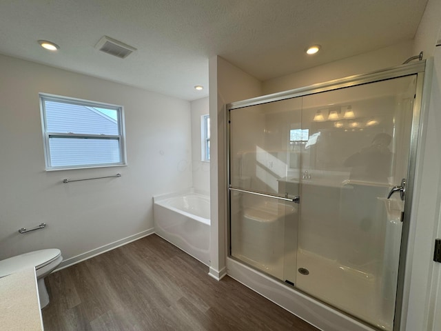 bathroom with toilet, plus walk in shower, a textured ceiling, and hardwood / wood-style flooring