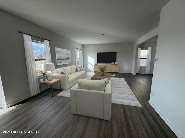 living room with a healthy amount of sunlight, dark wood-type flooring, and a textured ceiling