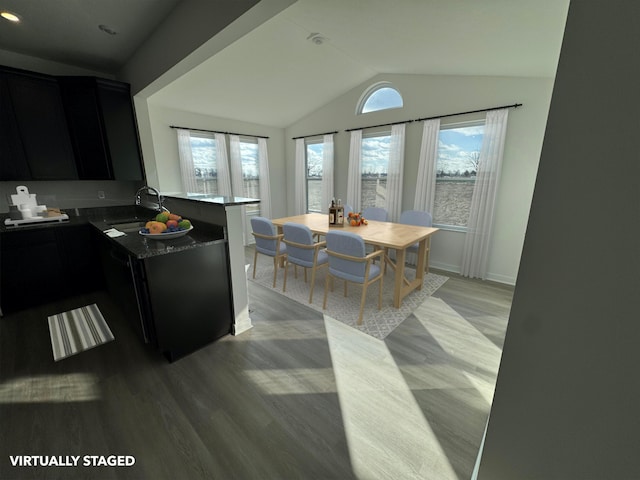 kitchen featuring kitchen peninsula, light hardwood / wood-style flooring, vaulted ceiling, and sink