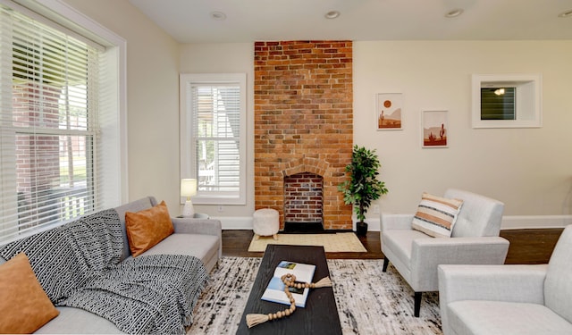 living room with a brick fireplace and light hardwood / wood-style flooring