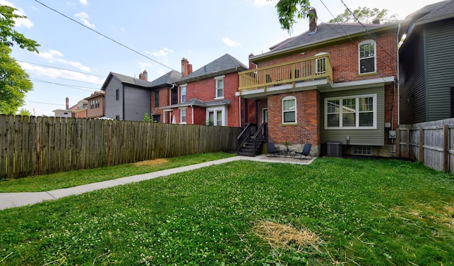 back of property featuring a lawn, a balcony, and central AC unit