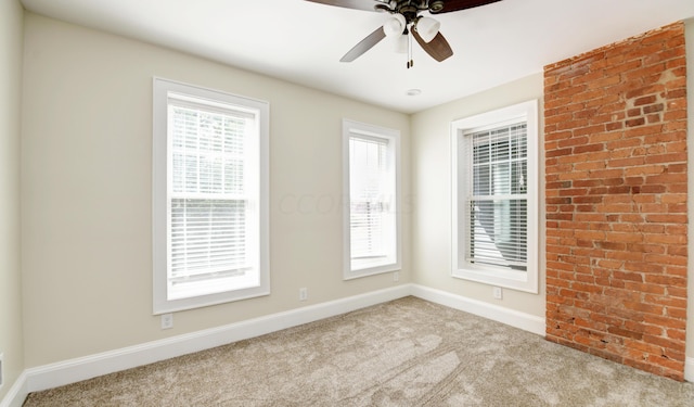 empty room featuring plenty of natural light, ceiling fan, and light carpet