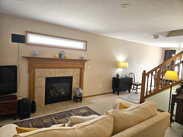 carpeted living room featuring a textured ceiling and a tiled fireplace