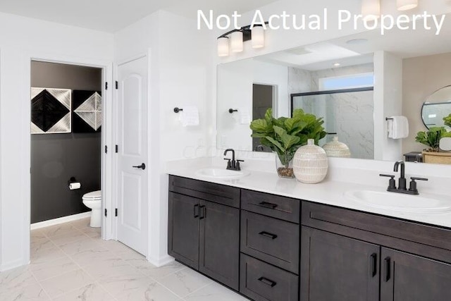 bathroom with vanity, toilet, and an enclosed shower