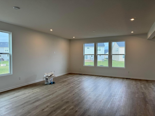 empty room with light hardwood / wood-style floors and a healthy amount of sunlight