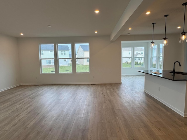 unfurnished living room with sink and light hardwood / wood-style flooring