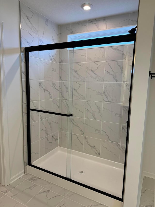 bathroom featuring a shower with shower door