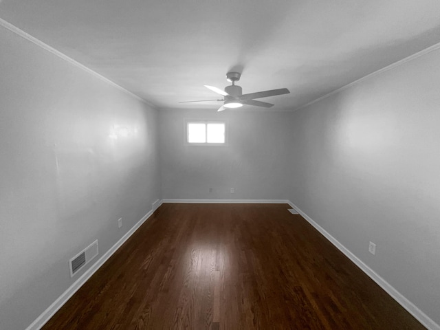 empty room with ceiling fan, ornamental molding, and dark wood-type flooring