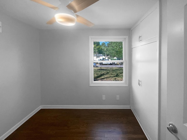 empty room with ceiling fan and dark hardwood / wood-style floors