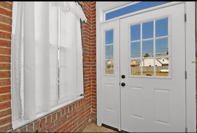 entryway featuring brick wall