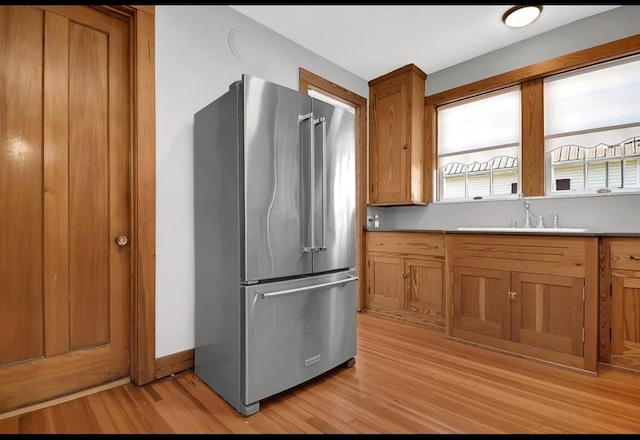 kitchen featuring light wood-type flooring, sink, and high end refrigerator