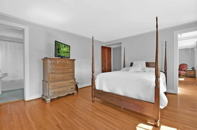 bedroom featuring wood-type flooring and connected bathroom