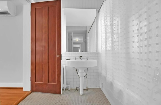 bathroom featuring tile patterned floors, sink, tile walls, and a wall mounted AC