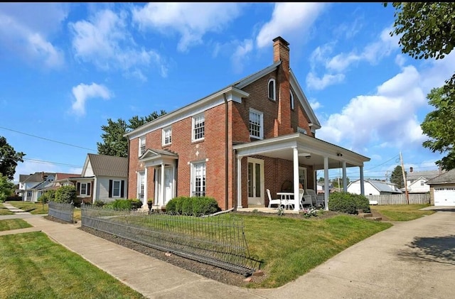 view of side of property featuring covered porch and a yard