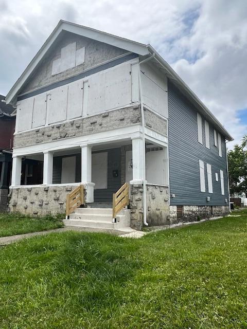 exterior space with covered porch and a lawn