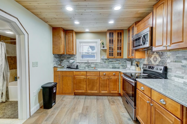 kitchen with appliances with stainless steel finishes, backsplash, sink, wooden ceiling, and light hardwood / wood-style floors