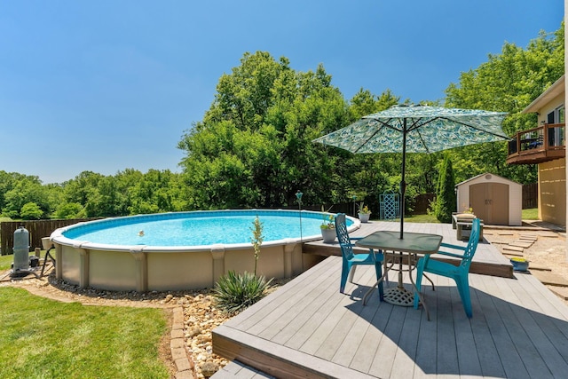 view of swimming pool with a wooden deck and a storage unit