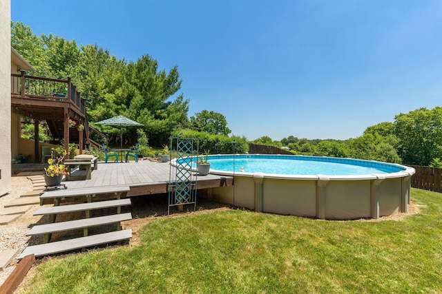 view of swimming pool with a yard and a deck