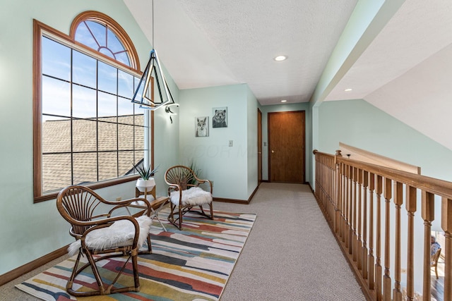 sitting room featuring lofted ceiling, light carpet, plenty of natural light, and a textured ceiling