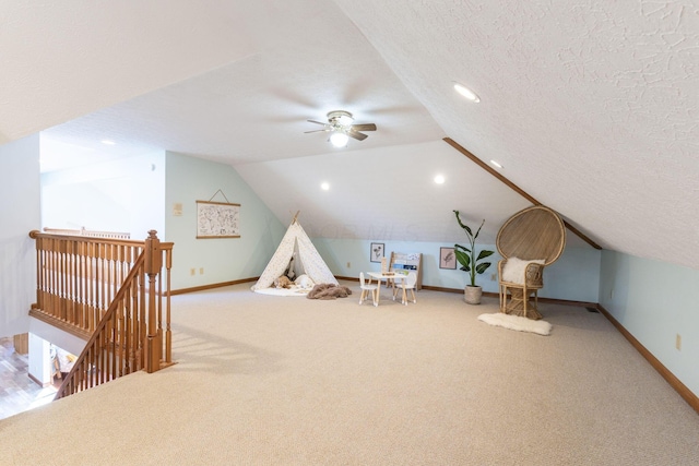 game room featuring lofted ceiling, ceiling fan, a textured ceiling, and carpet