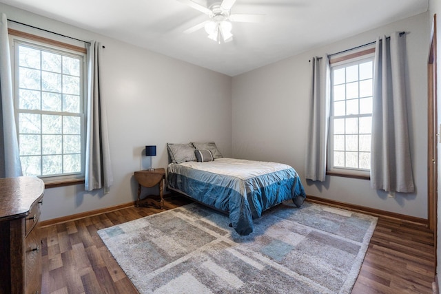 bedroom with ceiling fan, dark hardwood / wood-style floors, and multiple windows