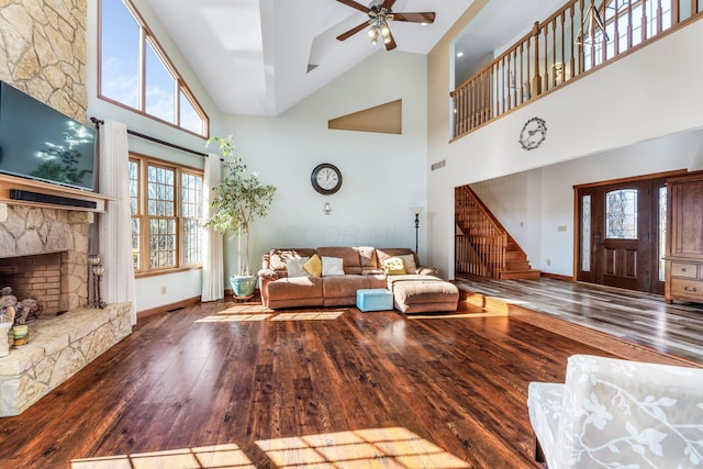 living room with dark wood-type flooring, a wealth of natural light, and a fireplace