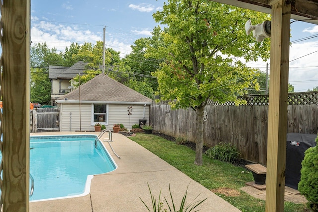 view of pool with a yard, a patio area, and an outdoor structure