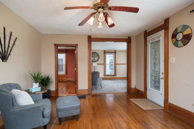 interior space with ceiling fan, wood-type flooring, and a textured ceiling