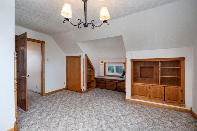 bonus room featuring light carpet, a textured ceiling, vaulted ceiling, and a notable chandelier