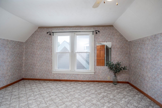 additional living space with carpet flooring, vaulted ceiling, and ceiling fan