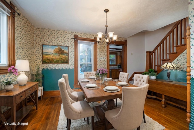 dining room with dark hardwood / wood-style flooring and a chandelier