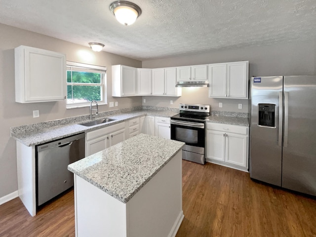 kitchen featuring appliances with stainless steel finishes, a kitchen island, dark wood-type flooring, and sink