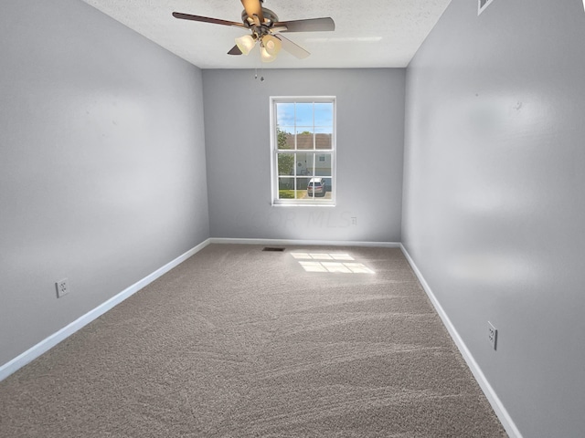 carpeted spare room featuring ceiling fan and a textured ceiling