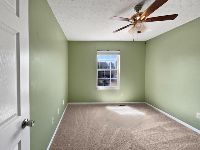 empty room featuring ceiling fan, carpet, and a textured ceiling