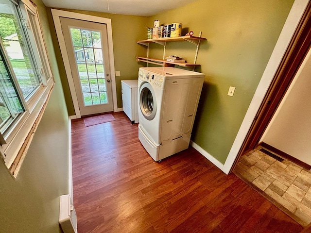 clothes washing area with washer and dryer and wood-type flooring