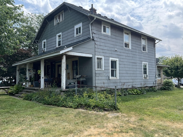 back of house with a lawn and a porch