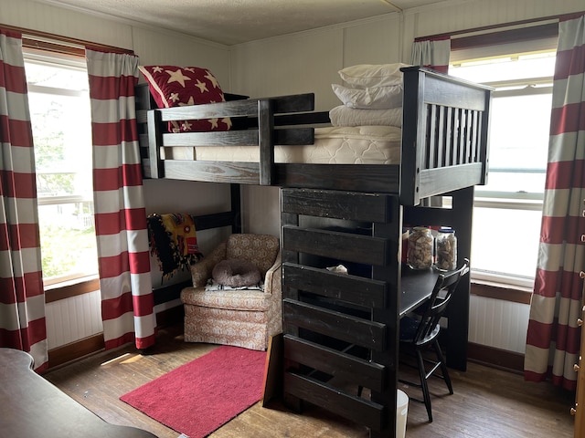 bedroom featuring multiple windows, wood-type flooring, and a textured ceiling