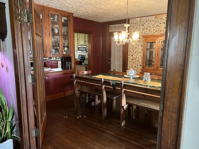 dining space featuring dark hardwood / wood-style floors and a notable chandelier