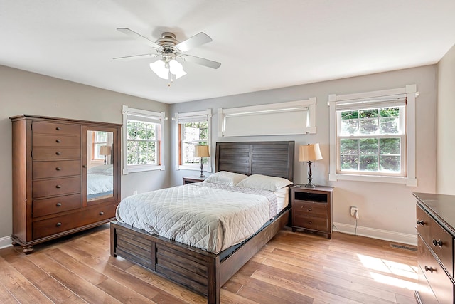 bedroom with light wood-type flooring, multiple windows, and ceiling fan