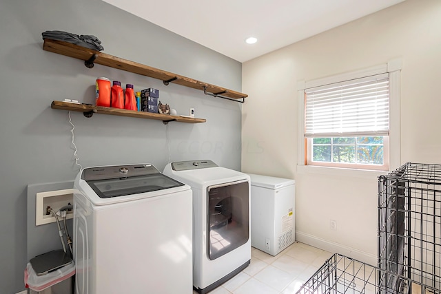 clothes washing area with independent washer and dryer and light tile patterned floors