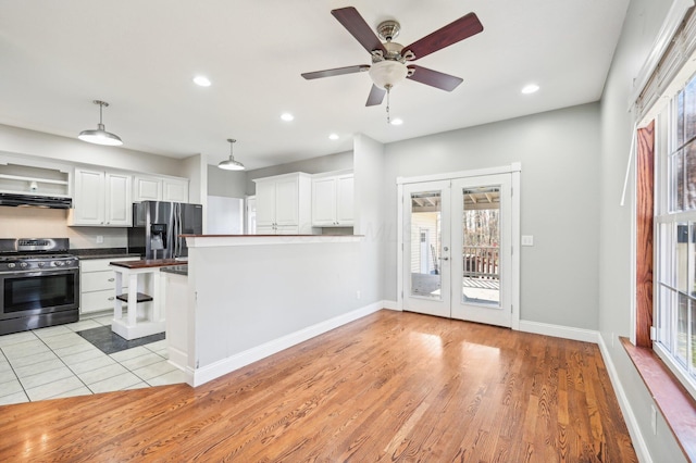 kitchen with a wealth of natural light, light hardwood / wood-style flooring, white cabinets, and appliances with stainless steel finishes