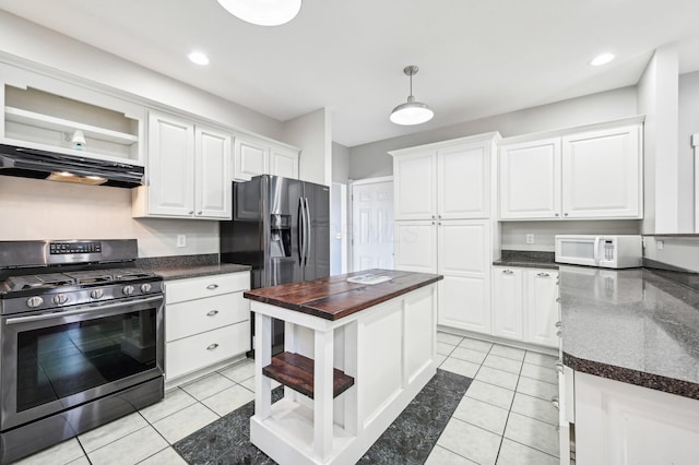 kitchen featuring white cabinets, appliances with stainless steel finishes, light tile patterned floors, and hanging light fixtures