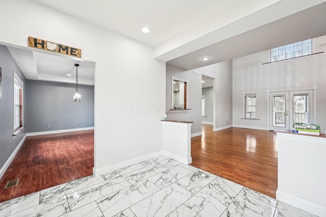 unfurnished living room featuring light hardwood / wood-style floors and french doors