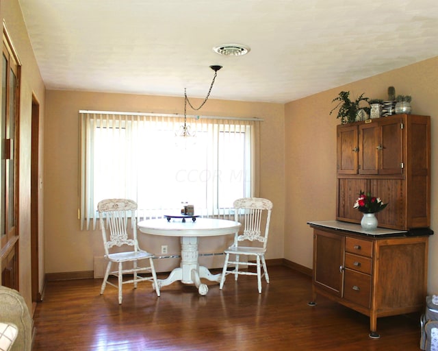 dining space featuring dark hardwood / wood-style flooring and a notable chandelier