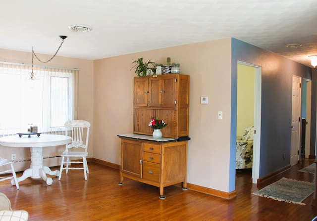 dining room with dark hardwood / wood-style floors and a chandelier